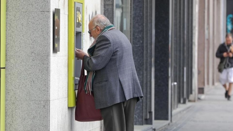 Señor sacando dinero de un cajero